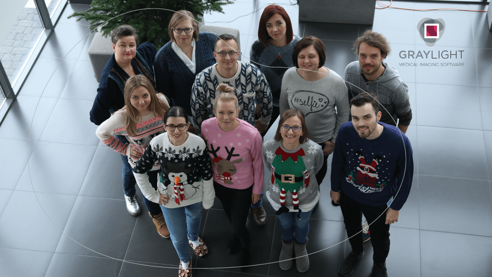 gruop of Graylight Imaging employees standing in christmass sweaters as an example of team provided by software outsourcing partner
