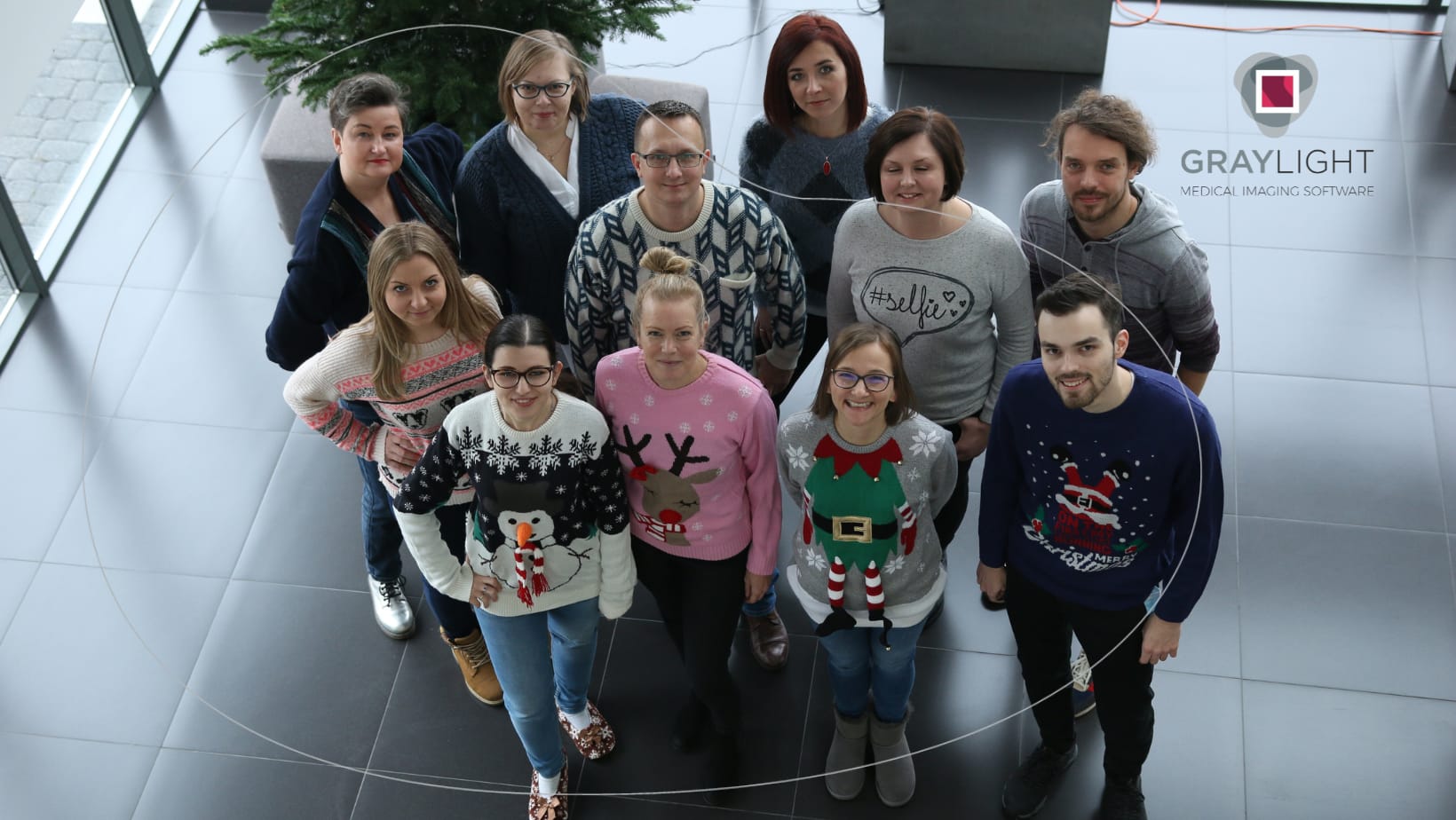 gruop of Graylight Imaging employees standing in christmass sweaters as an example of team provided by software outsourcing partner