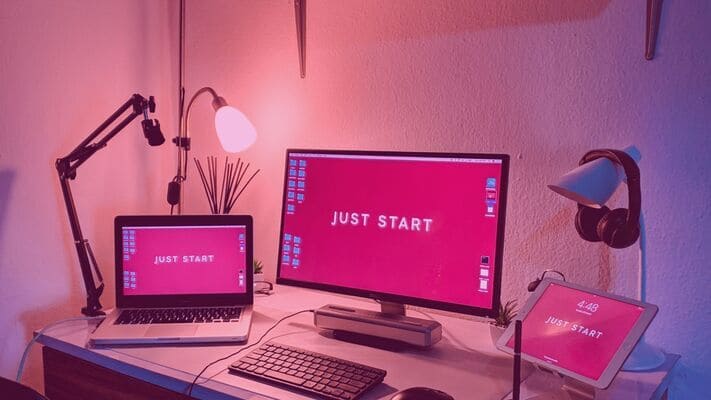 a room with three monitors with a phrase "just start", the user is about to just start reading about a grant partner