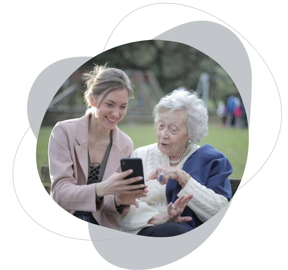 elder lady is talking with a younger woman . There is a park behind them.